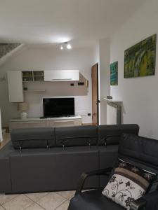 a living room with a couch and a flat screen tv at Sweet Home Airport Fiumicino in Fiumicino