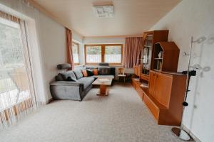 a living room with a couch and a tv at Ferienhäuser Inge und Seeblick in Oberaichwald