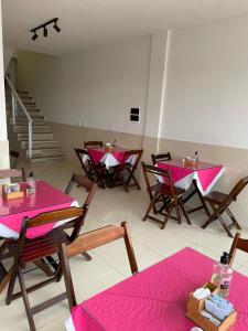 ピラーニャスにあるPousada Bonita , Piranhas ALのテーブルと椅子、ピンクのテーブルクロスが備わる客室です。