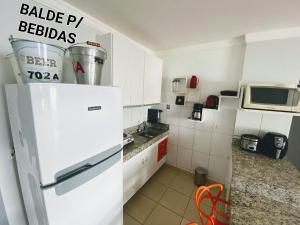 a kitchen with a white refrigerator and a microwave at Rio Quente GO Apto 7 Pessoas 2 Qtos in Rio Quente