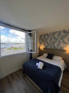 1 dormitorio con cama y ventana grande en Couett'Hôtel Brest, en Brest