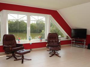 two chairs and a television in a room with windows at Appartementhaus am Kiessee, Westerholt in Westerholt