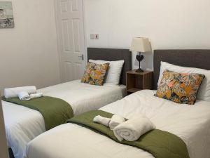 a bedroom with two beds with towels on them at Delightful Delta-Studio Apt Walk-2Leeds city WiFi in Leeds