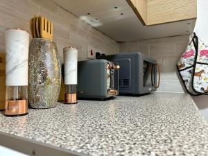 a kitchen counter with a microwave and three candles at Delightful Delta-Studio Apt Walk-2Leeds city WiFi in Leeds