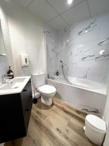 a bathroom with a toilet and a tub and a sink at Couett'Hôtel Brest in Brest