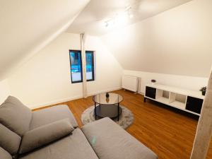 ein Wohnzimmer mit einem Sofa und einem Tisch in der Unterkunft Work & Stay Apartment near Hamburg in Ahrensburg