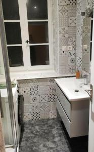 Elle comprend une petite salle de bains pourvue d'un lavabo et d'une fenêtre. dans l'établissement Appartement de Louise et Adrien, à Gray