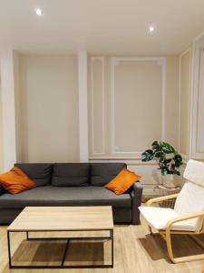 ein Wohnzimmer mit einem Sofa und einem Couchtisch in der Unterkunft Appartement de Louise et Adrien in Gray