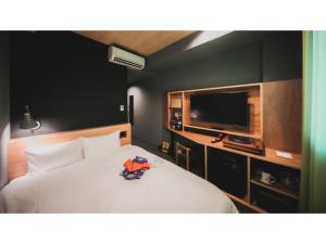 a bedroom with a white bed and a flat screen tv at dogo hakuro - Vacation STAY 79568v in Matsuyama