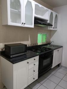 a kitchen with white cabinets and a black stove top oven at EL SOLAR in Guanajuato