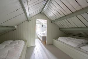 two beds in a room with white walls at Vesterålen Rorbuer in Bø i Vesterålen