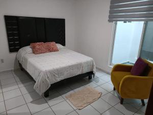 a bedroom with a bed and a couch and a chair at EL SOLAR in Guanajuato