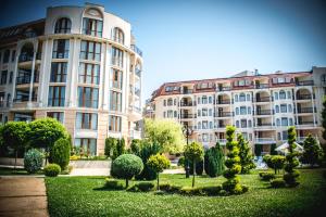 two large buildings with trees and bushes in a park at Apart Hotel Apolonia Palace in Sinemorets