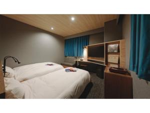 a hotel room with two beds and a television at dogo hakuro - Vacation STAY 80207v in Matsuyama