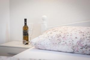 a bed with a bottle of wine and two glasses at Apartments Luka in Senj