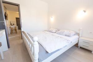 a white bed with two pillows on it in a bedroom at Apartments Luka in Senj