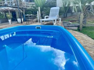 una piscina azul con mesa y silla en Espetacular! Casa em com vista deslumbrante en Governador Celso Ramos