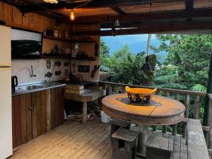 cocina con mesa de madera y cocina con encimera en Espetacular! Casa em com vista deslumbrante en Governador Celso Ramos