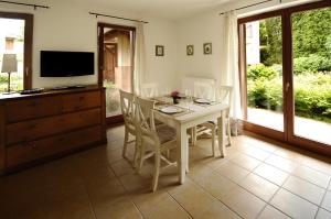 a dining room with a table and chairs and a television at Hullám Villa B&B in Balatonmáriafürdő
