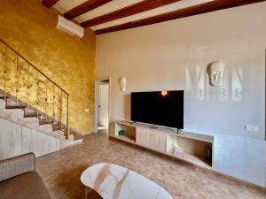 un salon avec une télévision à écran plat au mur dans l'établissement Sundorado, à San Bartolomé