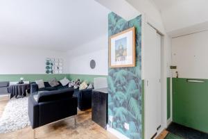 - un salon avec un canapé noir et un mur vert dans l'établissement Cosy 1bedroom Flat - 2 Min Walk to Kensington Gardens!, à Londres