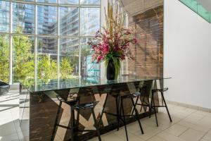 a glass table in a room with a vase with flowers at The Perfect Getaway in Toronto