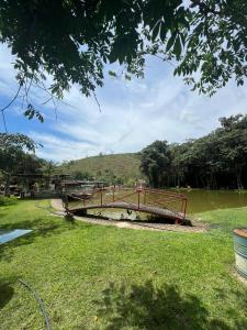 a bridge over a river in a park at Pesque pague pousada do Carlinho in Pinheiral