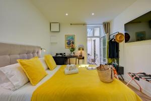 a bedroom with a large yellow bed with yellow pillows at Boutique Hôtel Provencia in Marseille