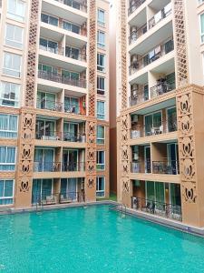 a swimming pool in front of a building at Atlantis Condo Resort in Jomtien Beach