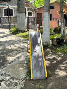 a slide in a park with a persons shadow on it at Pesque pague pousada do Carlinho in Pinheiral