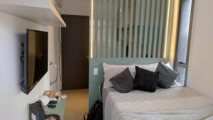 um quarto com uma cama com duas almofadas em VN Turiassu II em São Paulo