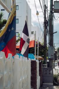 dwie flagi na płocie obok budynku w obiekcie Riviera Punta Cana Eco Travelers w Punta Cana