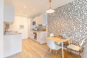 a kitchen and dining room with a table and chairs at Stunning 1bedroom Flat wBalcony - Surrey Quays! in London