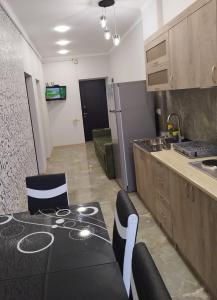uma cozinha com uma mesa preta e cadeiras num quarto em Квартира в центре города Ванадзор em Vanadzor