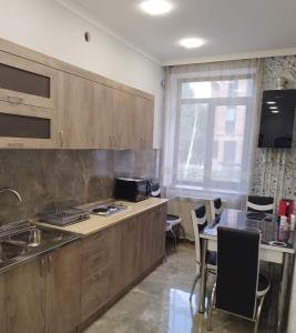 uma cozinha com armários de madeira e uma mesa e cadeiras em Квартира в центре города Ванадзор em Vanadzor