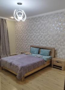 um quarto com uma cama e um lustre em Квартира в центре города Ванадзор em Vanadzor