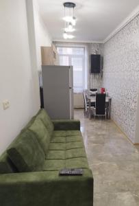 uma sala de estar com um sofá verde e uma mesa em Квартира в центре города Ванадзор em Vanadzor