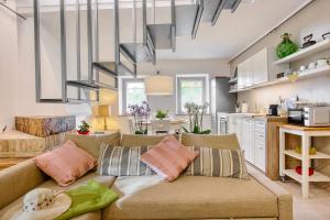 ein Wohnzimmer mit einem Sofa und einer Küche in der Unterkunft Borgo Canapegna - 2 private villas and 3 private pools in the heart of Le Marche in Fabriano