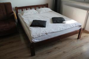a bed with two black pillows on top of it at Apartment Wielicka Cracow in Kraków