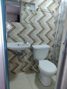 a bathroom with a toilet and a sink at Hostal Chorro De Quevedo in Bogotá