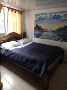Bett in einem Schlafzimmer mit Wandgemälde in der Unterkunft Hostal Chorro De Quevedo in Bogotá