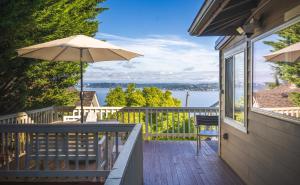 a porch with an umbrella and a table and chairs at Sunrise on Lake Washington in Seattle