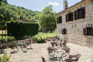 a patio with tables and chairs in front of a building at Ελευθερία in Asprangeloi