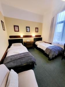 a hotel room with two beds and a window at Penzion Bazalka in Jablonec nad Nisou +19 photos