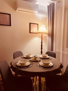 een tafel met borden en een lamp in een kamer bij Kilińskiego 35 in Ełk