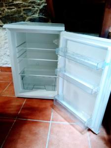 un réfrigérateur blanc vide avec sa porte ouverte dans l'établissement Casa Pacios by M de Santiago, à Tríacastela