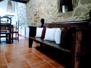 - un banc en bois avec des oreillers dans l'établissement Casa Pacios by M de Santiago, à Tríacastela