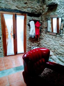 - un salon avec un fauteuil en cuir et un mur en pierre dans l'établissement Casa Pacios by M de Santiago, à Tríacastela