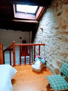 Habitación con balcón con maceta de flores y ventana. en Casa Pacios by M de Santiago, en Triacastela