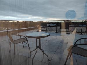 a table and two chairs on a balcony at ApartamentySnu, Bulwary II z parkingiem in Radom